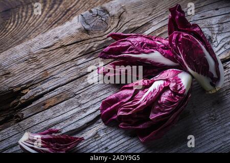 Fresco radicchio bambino su tavola di legno. Vegano sano impianto basato il cibo sulla tavola in legno rustico Foto Stock