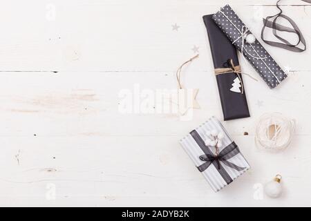 Vista dall'alto su Nizza regali di Natale Pranzo in bianco e nero e la carta a righe e decorate con stelle su sfondo di legno. E presenta elementi di arredamento. Holiday Foto Stock