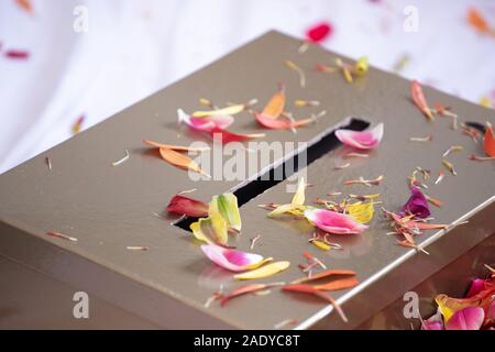 La religione sikh indiana tradizionale cerimonia rituale, elementi casella di donazione, mani fiori close up Foto Stock