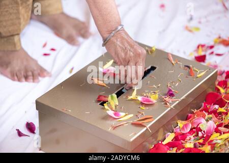 La religione sikh indiana tradizionale cerimonia rituale, elementi casella di donazione, mani fiori close up Foto Stock