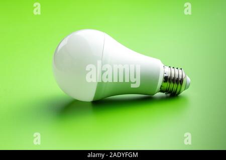 Risparmio energetico lampada luce su sfondo verde. Luce LED lampadina. Foto Stock
