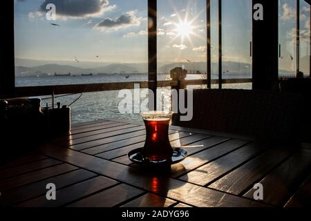 Tè turco contro il mare su di un tavolo di legno Foto Stock