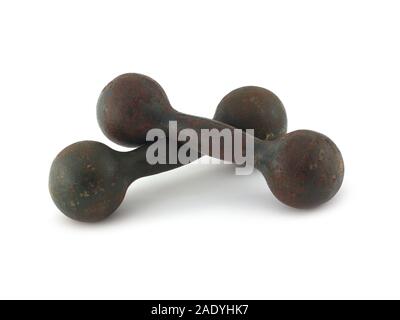 Due vecchi pesanti coperti con un tocco di ruggine dumbbells si trovano l'uno sull'altro isolato su sfondo bianco. Attrezzatura sportiva d'epoca in primo piano Foto Stock