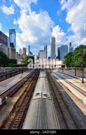 Chicago, Illinois, Stati Uniti d'America. Il treno dei pendolari che arrivano a Van Buren Street Station con un segmento dello skyline della città che sovrasta in background. Foto Stock