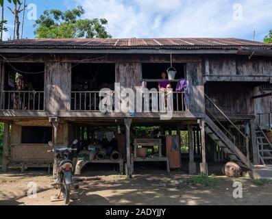 Un tradizionale villaggio birmano casa con tetto dello stagno, una costruzione in legno, sollevato palificazioni e open air outlook nel nord-ovest del Myanmar (Birmania) Foto Stock