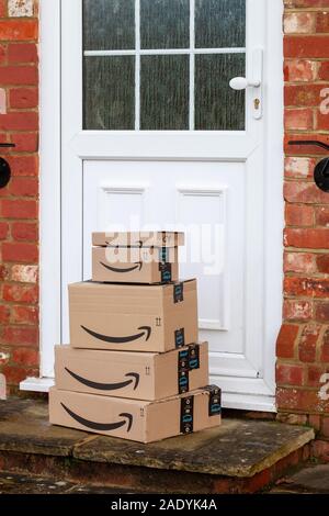 Pila di Amazon Prime caselle sulla sinistra su una porta Foto Stock