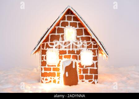 I fatti a mano mangiabile gingerbread house con luce interna e la decorazione di neve Foto Stock