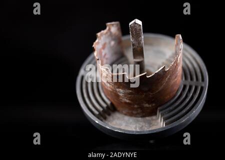 Vecchio sega per la realizzazione di fori di grandi dimensioni in legno. Accessori per lavorare nel laboratorio di falegnameria. Sfondo scuro. Foto Stock