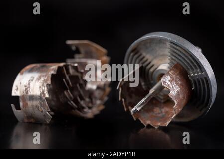 Vecchio sega per la realizzazione di fori di grandi dimensioni in legno. Accessori per lavorare nel laboratorio di falegnameria. Sfondo scuro. Foto Stock