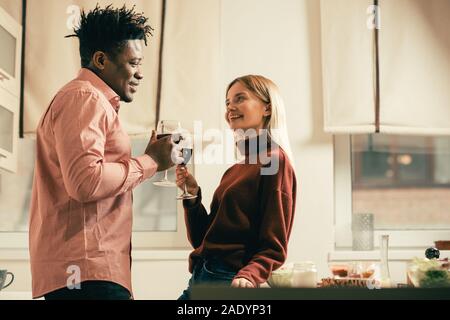Vita di donna in piedi vicino al tavolo e bere il vino con uomo Foto Stock