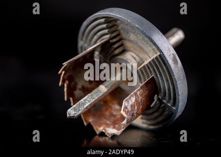 Vecchio sega per la realizzazione di fori di grandi dimensioni in legno. Accessori per lavorare nel laboratorio di falegnameria. Sfondo scuro. Foto Stock