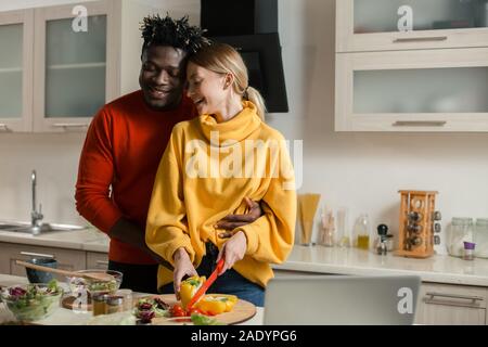 Felice Coppia sorridente in cucina durante la cottura Foto Stock