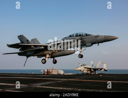 Un U.S. Navy F/A-18F Super Hornet fighter aircraft con il jolly Rogers di Strike Fighter Squadron 103, rende un arrestato lo sbarco a bordo della Nimitz-class portaerei USS Abraham Lincoln a sostegno di funzionamento inerenti risolvere Dicembre 3, 2019 nel Golfo Arabico. Foto Stock