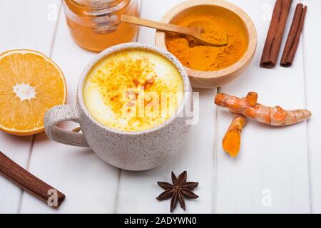 Detox curcuma tè golden latte e ingredienti su bianco tavolo in legno Foto Stock