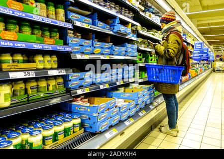 Donna con telefono cellulare shopping nel negozio Tesco, supermercati scaffali di formaggio Foto Stock