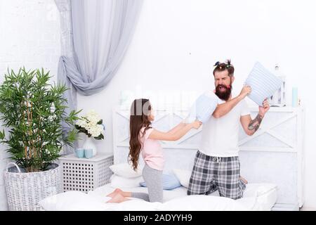 La famiglia felice. Il ruolo del padre. Pillow Fight. Papà cerca di vivere una vita di integrità e onestà. Sincere emozioni. Padre e figlia avendo divertimento. Pigiama Party. Infanzia felice. Educazione felice figlia. Foto Stock