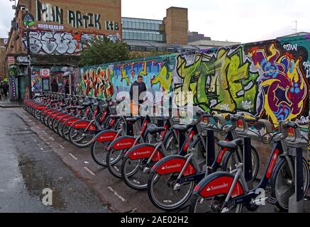 Le biciclette Santander, Boris Bike, parcheggiate alla fine di Shoreditch di Brick Lane, Londra, Inghilterra, Regno Unito Foto Stock