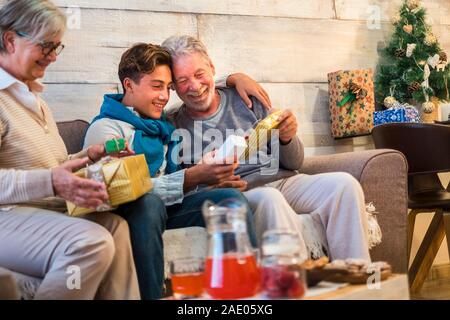 La famiglia a casa godendo e celebrare il tempo di Natale notte insieme con presenta gits e per il tradizionale scambio - happy nonni con grand Foto Stock