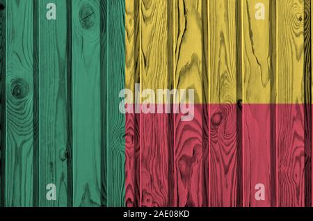 Benin bandiera rappresentata in luminosi colori di vernice sul vecchio muro di legno vicino. Textured banner su sfondo irregolare Foto Stock
