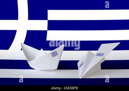 Bandiera della Grecia rappresentato su carta origami aeroplano e barca. Oriental arti artigianali concept Foto Stock