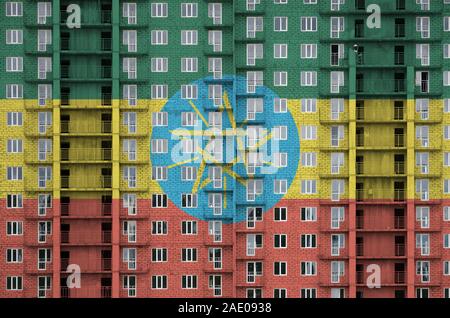 Etiopia bandiera raffigurata in colori di vernice su più piani edificio residenziale in costruzione. Textured banner sul grande muro di mattoni in background Foto Stock