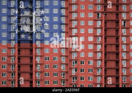 Myanmar bandiera raffigurata in colori di vernice su più piani edificio residenziale in costruzione. Textured banner sul grande muro di mattoni in background Foto Stock