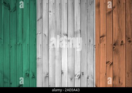 Irlanda bandiera rappresentata in luminosi colori di vernice sul vecchio muro di legno vicino. Textured banner su sfondo irregolare Foto Stock