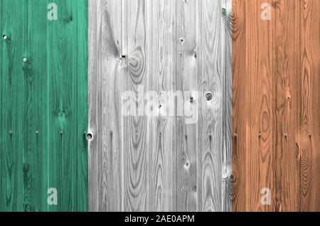 Irlanda bandiera rappresentata in luminosi colori di vernice sul vecchio muro di legno vicino. Textured banner su sfondo irregolare Foto Stock