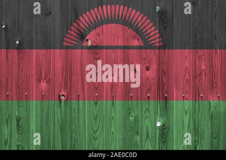 Il Malawi bandiera rappresentata in luminosi colori di vernice sul vecchio muro di legno vicino. Textured banner su sfondo irregolare Foto Stock