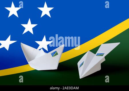 Isole Salomone bandiera raffigurata sulla carta origami aeroplano e barca. Oriental arti artigianali concept Foto Stock