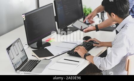 Programmatori che lavorano con essi e computer tablet in ufficio moderno. Foto Stock