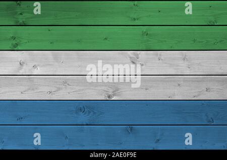 Sierra Leone bandiera rappresentata in luminosi colori di vernice sul vecchio muro di legno vicino. Textured banner su sfondo irregolare Foto Stock