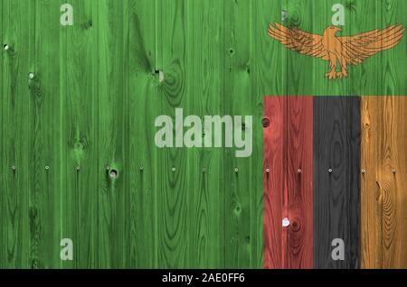 Zambia bandiera rappresentata in luminosi colori di vernice sul vecchio muro di legno vicino. Textured banner su sfondo irregolare Foto Stock