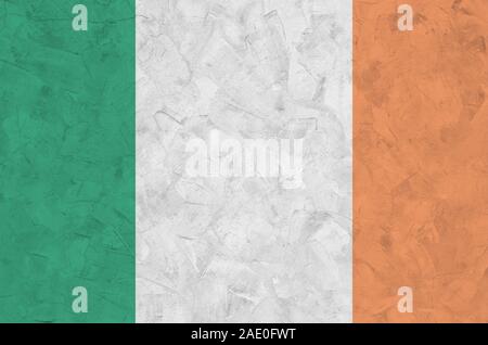 Irlanda bandiera rappresentata in luminosi colori di vernice su vecchi intonaci a rilievo parete vicino. Textured banner su sfondo irregolare Foto Stock