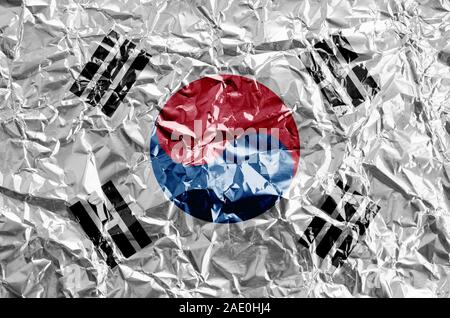 Corea del Sud bandiera raffigurata in colori di vernice su shiny accartocciata lamina di alluminio vicino. Textured banner su sfondo irregolare Foto Stock