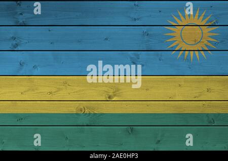 Ruanda bandiera rappresentata in luminosi colori di vernice sul vecchio muro di legno vicino. Textured banner su sfondo irregolare Foto Stock