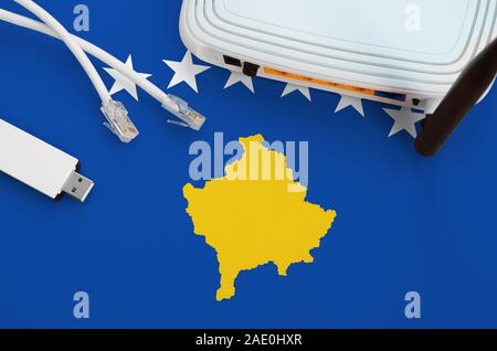 Il Kosovo bandiera raffigurata sulla tabella con internet cavo RJ45, USB wireless wi-fi adattatore e router. Connessione a Internet concept Foto Stock