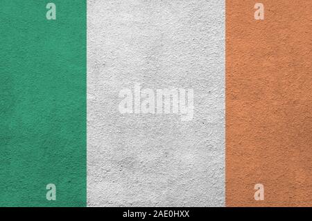 Irlanda bandiera rappresentata in luminosi colori di vernice su vecchi intonaci a rilievo parete vicino. Textured banner su sfondo irregolare Foto Stock