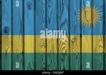 Ruanda bandiera rappresentata in luminosi colori di vernice sul vecchio muro di legno vicino. Textured banner su sfondo irregolare Foto Stock