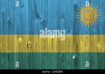 Ruanda bandiera rappresentata in luminosi colori di vernice sul vecchio muro di legno vicino. Textured banner su sfondo irregolare Foto Stock