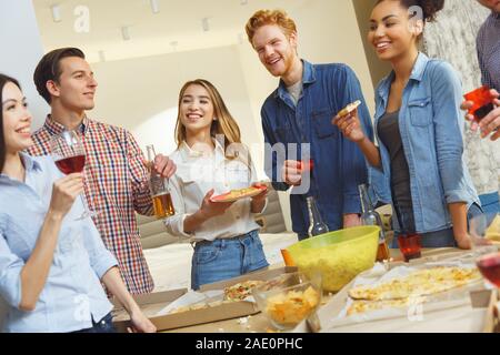 Gruppo di amici aventi parti in ambienti chiusi insieme divertimento festeggia il compleanno casual Foto Stock