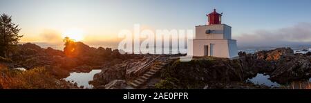 Bella vista panoramica del faro sul roccioso costa dell'Oceano Pacifico durante un colorato nuvoloso sunrise. Prese su Wild Pacific Trail in Ucluelet, Foto Stock