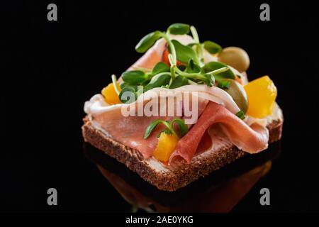 Close up di prosciutto su preparati smorrebrod danese sandwich su nero Foto Stock