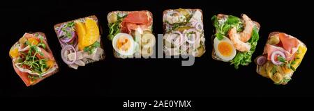 Panoramica del pane di segale con preparati smorrebrod danese sandwich isolati su nero Foto Stock