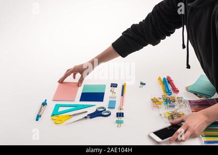 Vista ritagliata del fotografo rendendo laici piatta con forniture per ufficio commerciale per il tiro di foto sullo smartphone Foto Stock