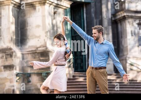 Coppia di giovani, turisti elegante danza su strada in presenza di luce solare Foto Stock