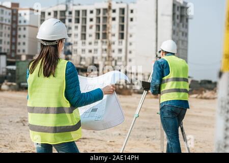 Geometri con blueprint e livello digitale lavorando sul sito in costruzione Foto Stock