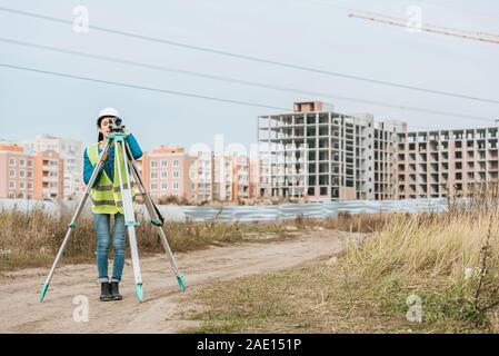 Geometra terra di misurazione con livello digitale sul sito in costruzione Foto Stock