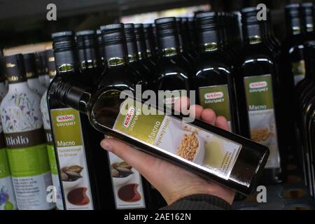 Tyumen, Russia - 20 Novembre 2019: kotanyi bottiglia di olio di semi di lino in mano del compratore, shopping in ipermercati. Foto Stock