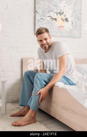 Turbare l uomo toccando gamba mentre soffre di muscolo del polpaccio dolore Foto Stock